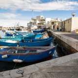 Camminiamo dunque su questa lingua di pietra, affiancando tante barchette e procedendo verso la punta del molo, l� dove un cancello in ferro d� accesso ai ripostigli riservati ai pescatori...